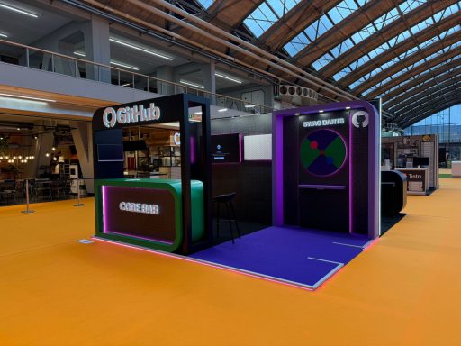 Github Exhibition stand featuring interactive displays and vibrant purple and green design.